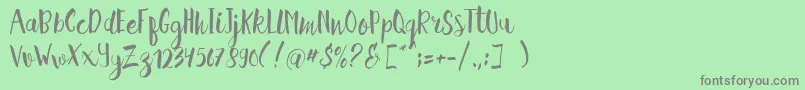 フォントHellena Script Free Sample – 緑の背景に灰色の文字