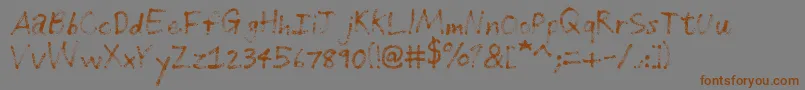 フォントGrungeHandwriting – 茶色の文字が灰色の背景にあります。
