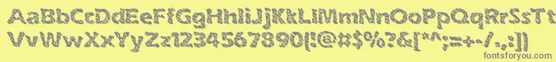 inkswipe-fontti – harmaat kirjasimet keltaisella taustalla