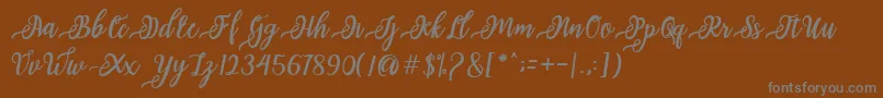 Fonte issabeta Script – fontes cinzas em um fundo marrom