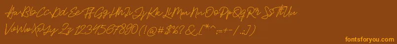 フォントJackson Script – オレンジ色の文字が茶色の背景にあります。