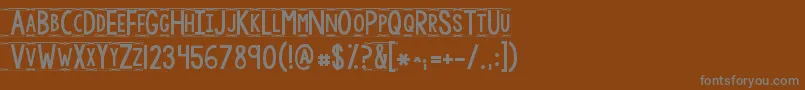 Kgmodernmonogram-fontti – harmaat kirjasimet ruskealla taustalla