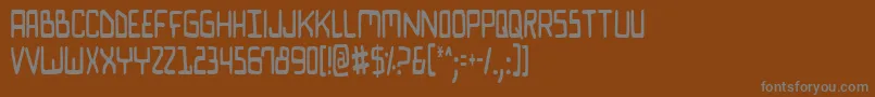 Biocomv2c-fontti – harmaat kirjasimet ruskealla taustalla