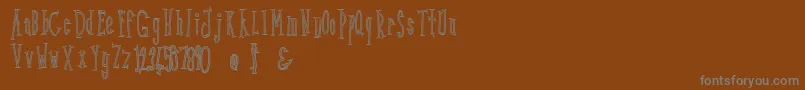 Kunang Kunang outline-Schriftart – Graue Schriften auf braunem Hintergrund