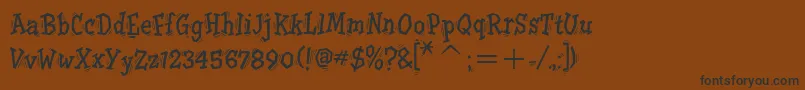 フォントTremoritcTt – 黒い文字が茶色の背景にあります