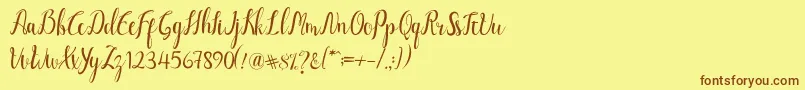 フォントLuciana Script – 茶色の文字が黄色の背景にあります。