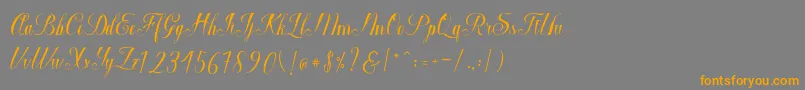 フォントMacrofhyllya Script – オレンジの文字は灰色の背景にあります。