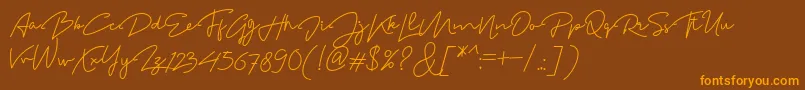 フォントMadelonScript – オレンジ色の文字が茶色の背景にあります。