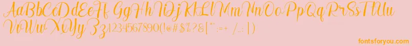 フォントMadelyn – オレンジの文字がピンクの背景にあります。