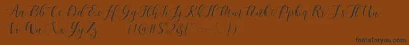 フォントMaheisa Script Free – 黒い文字が茶色の背景にあります