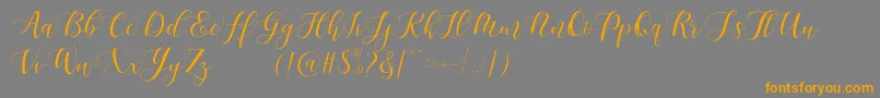 Maheisa Script Free-Schriftart – Orangefarbene Schriften auf grauem Hintergrund