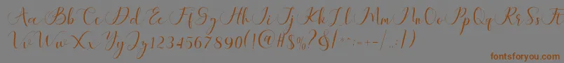 フォントMaheria Script – 茶色の文字が灰色の背景にあります。