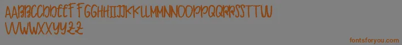 Makaw Free-Schriftart – Braune Schriften auf grauem Hintergrund