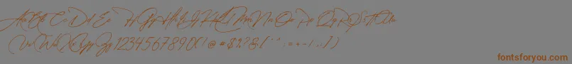 フォントManchester Signature – 茶色の文字が灰色の背景にあります。