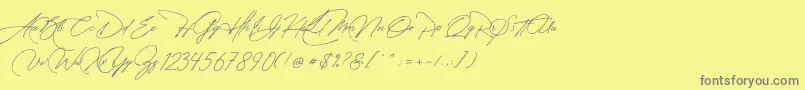 フォントManchester Signature – 黄色の背景に灰色の文字