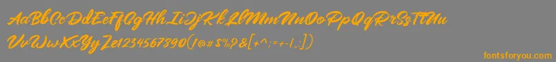 Mangotea   FREE PERSONAL USE-Schriftart – Orangefarbene Schriften auf grauem Hintergrund