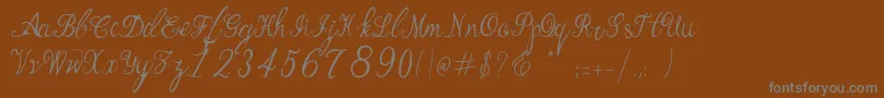 Manhattan Script-fontti – harmaat kirjasimet ruskealla taustalla