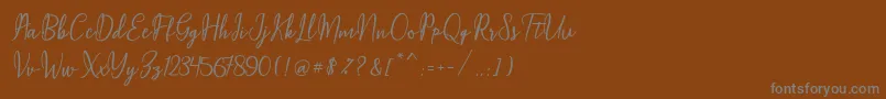 Czcionka Maqella Script – szare czcionki na brązowym tle