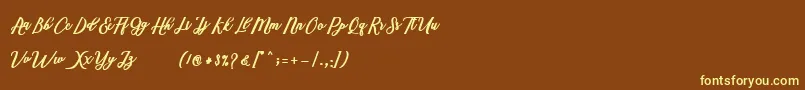 Marcela Script-Schriftart – Gelbe Schriften auf braunem Hintergrund