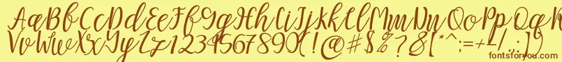フォントMellitta script – 茶色の文字が黄色の背景にあります。