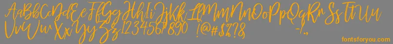 mellony dry brush-Schriftart – Orangefarbene Schriften auf grauem Hintergrund