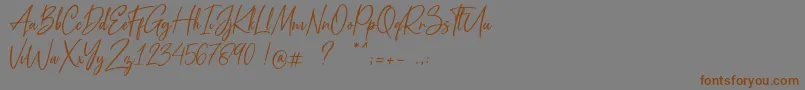 フォントMetal Pen – 茶色の文字が灰色の背景にあります。
