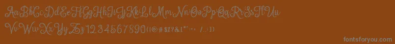 mettical-fontti – harmaat kirjasimet ruskealla taustalla