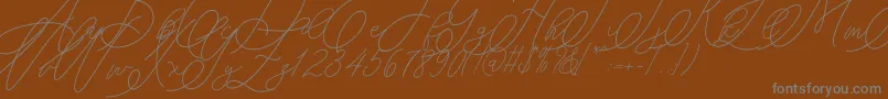 mondayline-fontti – harmaat kirjasimet ruskealla taustalla