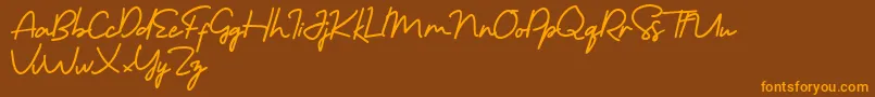 フォントMorning Gold Free – オレンジ色の文字が茶色の背景にあります。