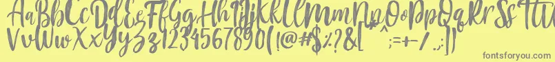 Fonte Mountain Script   Brush Font – fontes cinzas em um fundo amarelo