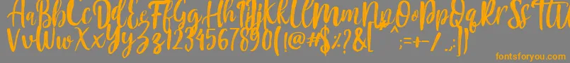 フォントMountain Script   Brush Font – オレンジの文字は灰色の背景にあります。