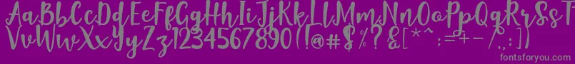 Naishila Dancing Script-fontti – harmaat kirjasimet violetilla taustalla