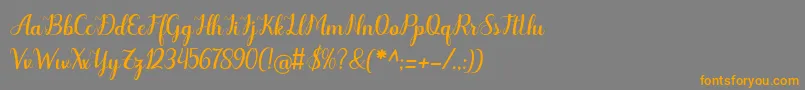 フォントOdelette – オレンジの文字は灰色の背景にあります。