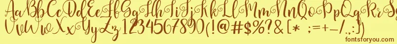 フォントPretty Queen – 茶色の文字が黄色の背景にあります。