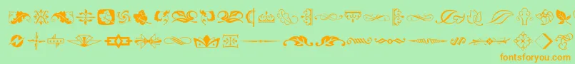 フォントArtornament – オレンジの文字が緑の背景にあります。