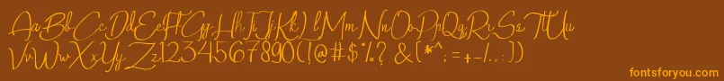 フォントQalinHandwritting – オレンジ色の文字が茶色の背景にあります。