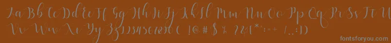 Weitere Informationen zur Qatielia Script-Schriftart Qatielia Script-Schriftart – Graue Schriften auf braunem Hintergrund