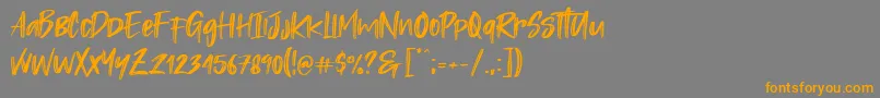 フォントRastazm – オレンジの文字は灰色の背景にあります。