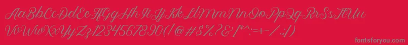 Fonte Royalite Script – fontes cinzas em um fundo vermelho