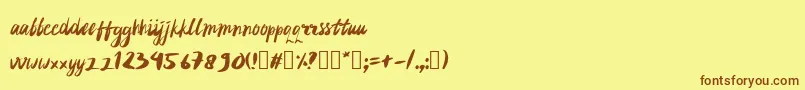 フォントrujakpetis – 茶色の文字が黄色の背景にあります。