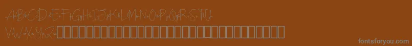 Scripty Demo-fontti – harmaat kirjasimet ruskealla taustalla