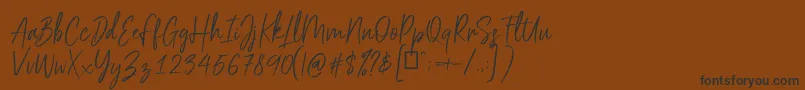 フォントScriptyca – 黒い文字が茶色の背景にあります