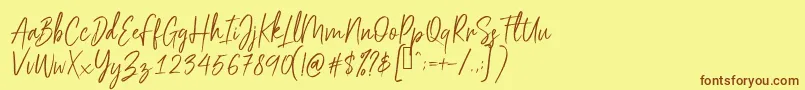 フォントScriptyca – 茶色の文字が黄色の背景にあります。