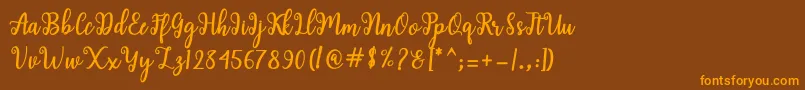 Czcionka Shaila Script – pomarańczowe czcionki na brązowym tle