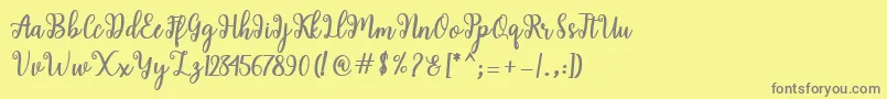 Shaila Script-fontti – harmaat kirjasimet keltaisella taustalla