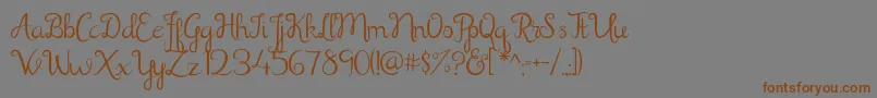 フォントShathika – 茶色の文字が灰色の背景にあります。
