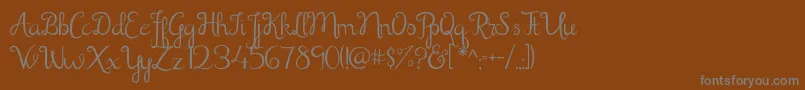 フォントShathika – 茶色の背景に灰色の文字