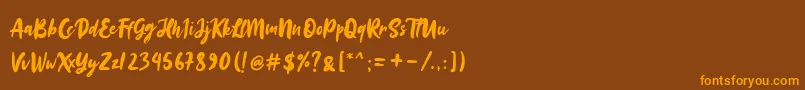 フォントSinestta – オレンジ色の文字が茶色の背景にあります。