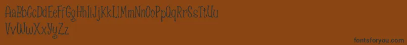 Spizzella Free font-Schriftart – Schwarze Schriften auf braunem Hintergrund