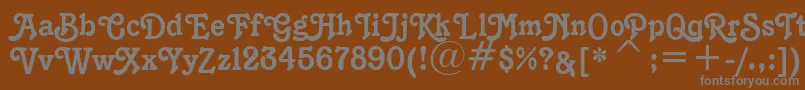 K1996J-fontti – harmaat kirjasimet ruskealla taustalla